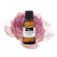 Purenaturenz Rose Centifolia Absolute essential oil in a glass bottle with a rose flower and green leaves.